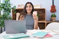 Young teenager girl studying using computer laptop screaming proud, celebrating victory and success very excited with raised arms Royalty Free Stock Photo