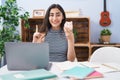 Young teenager girl studying using computer laptop surprised with an idea or question pointing finger with happy face, number one Royalty Free Stock Photo