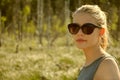 A young teenager girl with sunglasses in nature surroundings