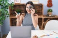 Young teenager girl using computer laptop with doughnut on face smiling happy pointing with hand and finger to the side Royalty Free Stock Photo