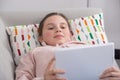 Young teenager girl using tablet computer sitting in the sofa Royalty Free Stock Photo