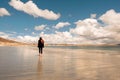 Young teenager girl walking on a warm sand of Gurteen beach, county Galway, Ireland. Warm sunny day. Cloudy sky. Outdoor activity Royalty Free Stock Photo