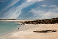 Young teenager girl walking on a warm sand of Gurteen beach, county Galway, Ireland. Warm sunny day. Cloudy sky. Outdoor activity Royalty Free Stock Photo