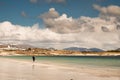 Young teenager girl walking on a warm sand of Gurteen beach, county Galway, Ireland. Warm sunny day. Cloudy sky. Outdoor activity Royalty Free Stock Photo