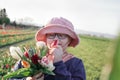 Young teenager girl wearing glasses, holding and smelling a big bunch of tulips, Royalty Free Stock Photo