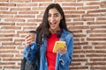 Young teenager girl wearing student backpack using smartphone celebrating crazy and amazed for success with open eyes screaming Royalty Free Stock Photo