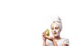 Young Teenager girl with white mask on face holding avocado fruit. Teen girl taking care of her skin, cleaning the pores. concept Royalty Free Stock Photo