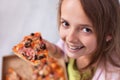 Young teenager girl with wide smile showing her favorite meal