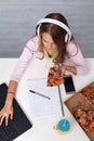 Young teenager girl working on a school project - having a snack Royalty Free Stock Photo