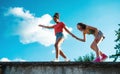 Young teenager girls friends outdoors in city, standing on concrete wall. Royalty Free Stock Photo