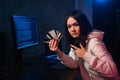 Young teenager hacker girl in hoodie holding credit card violating private password holding credit card in cybercrime Royalty Free Stock Photo