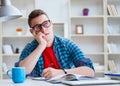 Young teenager preparing for exams studying at a desk indoors Royalty Free Stock Photo