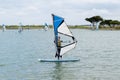 Young teenager woman windsurfing on the lake of the island of re windsurf board