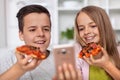 Young teenagers eating pizza slices and taking a selfie