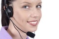 Young adult female telephonist with telephone headset, smiling, eyes looking at camera, close up Royalty Free Stock Photo