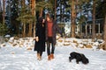 Young tender couple in love walking in winter park with dog Royalty Free Stock Photo