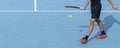 Young tennis player playing with ball and racket on blue hard tennis court. Sports active game Tennis banner, copy space Royalty Free Stock Photo