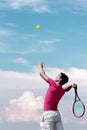 Young tennis player teen with racket hits flying ball in jump. Cute male tennis player athlete in action. Copy space Royalty Free Stock Photo