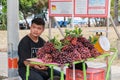 Young Thai man sells grapes on the side of the road next to the beach