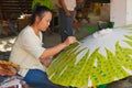 Young Thai woman paints traditional bamboo umbrella at the factory in Chiang Mai, Thailand.