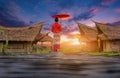 Young Thai woman wearing traditional Lanna clothing walks on a bamboo bridge in the middle of a rice field with a backdrop of a Royalty Free Stock Photo