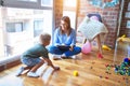 Young therapist woman speaking with child, counselor and behaviour correction at the office around toys