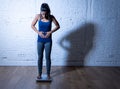 Young thin fit girl on scale obsessed with weight gain feeling fat and desperate Royalty Free Stock Photo