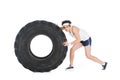 Young thin sportsman pushing tire of wheel