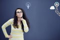 Young thinkful woman on blue gray background with finance graphs.