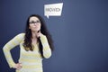 Young thinkful woman on blue gray background with finance graphs.