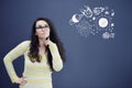 Young thinkful woman on blue gray background with universum icons.