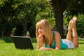 Young thinking girl on the grass with notebook Royalty Free Stock Photo