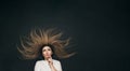 Young thinking woman with long hair lying on black studio background, girl brainstoming hard top view