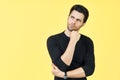 Young thoughtful man thinking and looking aside on copy space isolated on yellow background Royalty Free Stock Photo