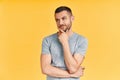 Young thoughtful man thinking and looking aside on copy space isolated on yellow background Royalty Free Stock Photo