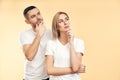 Young thoughtful man and woman looking sideways isolated on beige background Royalty Free Stock Photo