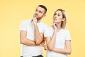 Young thoughtful man and woman looking sideways on yellow background. Royalty Free Stock Photo