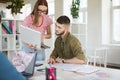 Young thoughtful man in shirt and woman in T-shirt and eyeglasses thoughtfully working together with laptop. Business