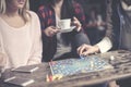 Three girls play together a social game. Focus on hand.