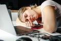 Young tired business woman works at home online, she fell asleep at table working on laptop. Fatigue and burnout Royalty Free Stock Photo