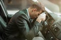 Young tired businessman sitts in his car looks exhausted, stressfull working conditions concept Royalty Free Stock Photo
