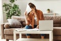 Pensive stressful female employee examining reports while working on complicated project at home