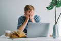 Young tired man college student studying with books and laptop distantly Royalty Free Stock Photo