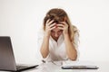 Young tired, stressed and frustrated business woman desperate working at office with laptop