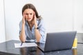 Young tired woman sitting in front of laptop while touching her forehead during work over project Royalty Free Stock Photo