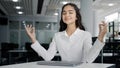 Young tired woman office worker working on laptop typing report finishes work calm balanced female manager meditates Royalty Free Stock Photo