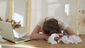 Young tired woman sleeping at her office desk near the laptop Royalty Free Stock Photo