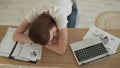 Young tired woman sleeping at her office desk near the laptop Royalty Free Stock Photo