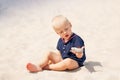 Young  toddler boy kid playing in sea beach sand stone Royalty Free Stock Photo