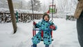 Young toddler boy smiling as he swings in the snow-covered park on a cold winter day. Perfect for conveying the joy and magic of Royalty Free Stock Photo